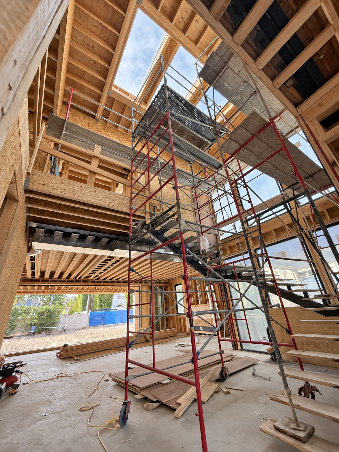 Double-height custom home framing in progress by DG Builders